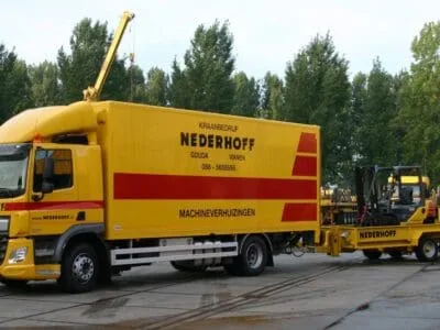 De bakwagen voor machineverhuizingen met een aanhangwagen met heftruck